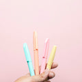 Four assorted-color gel pens on a light surface