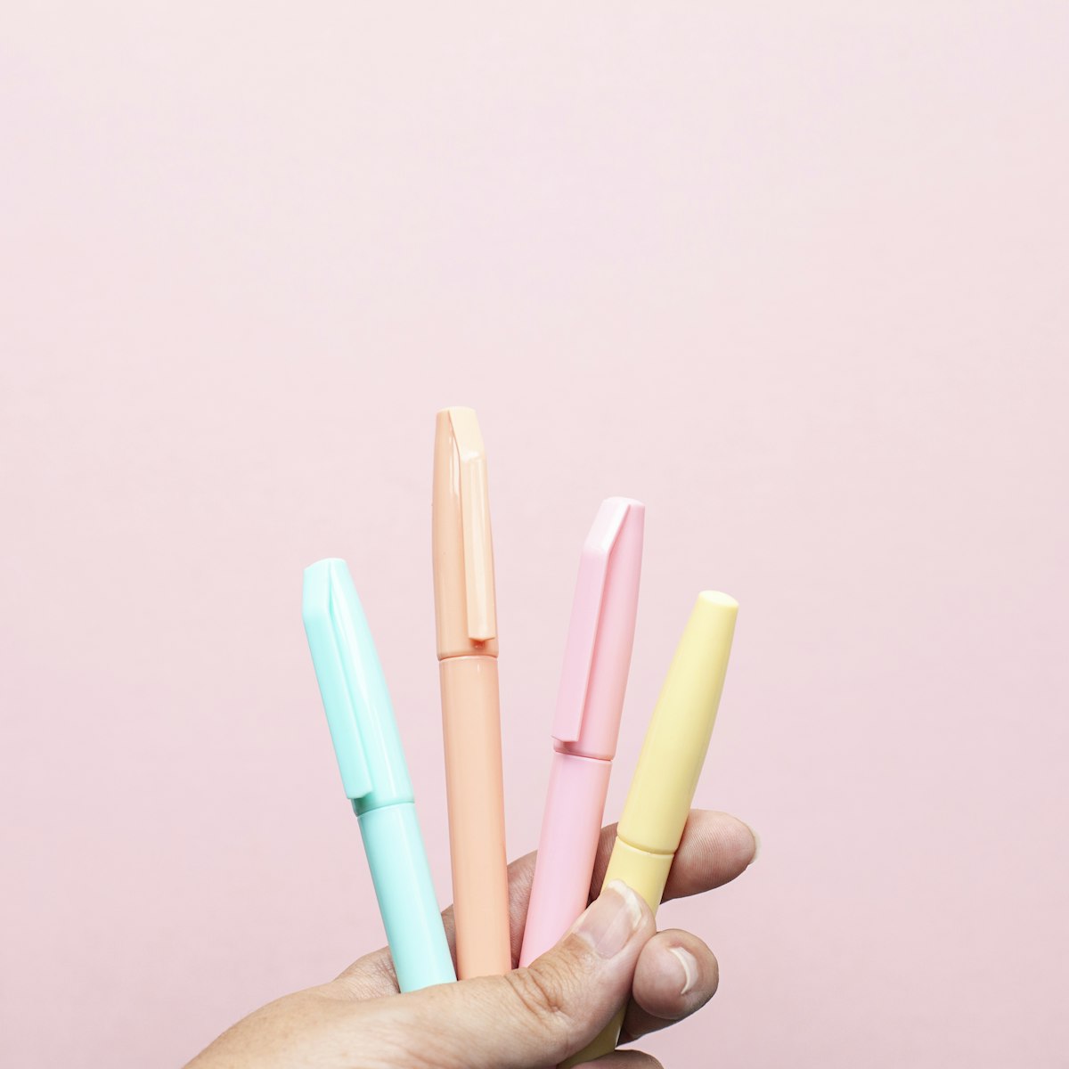 Four assorted-color gel pens on a light surface