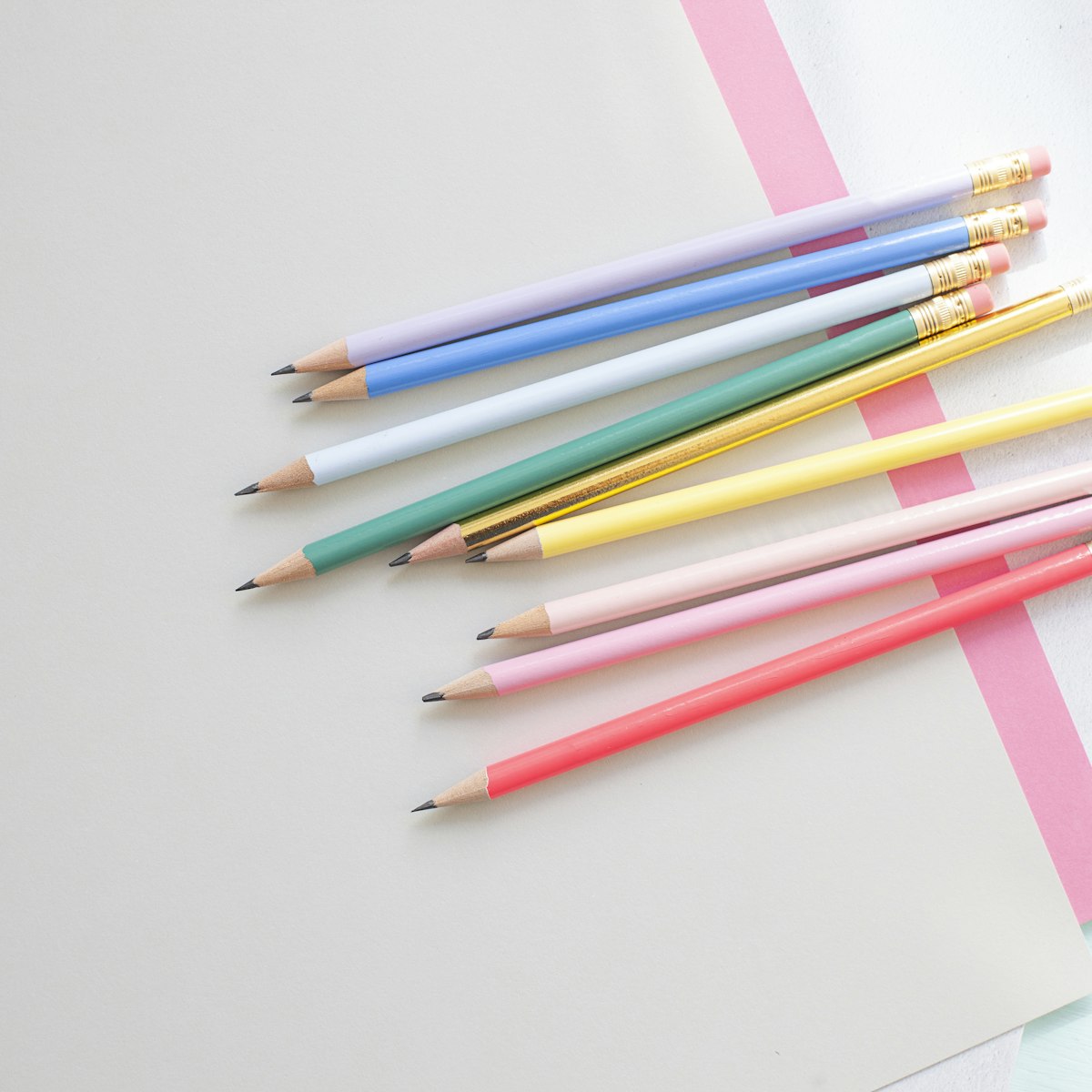 Assorted colored pencils arranged on a white surface