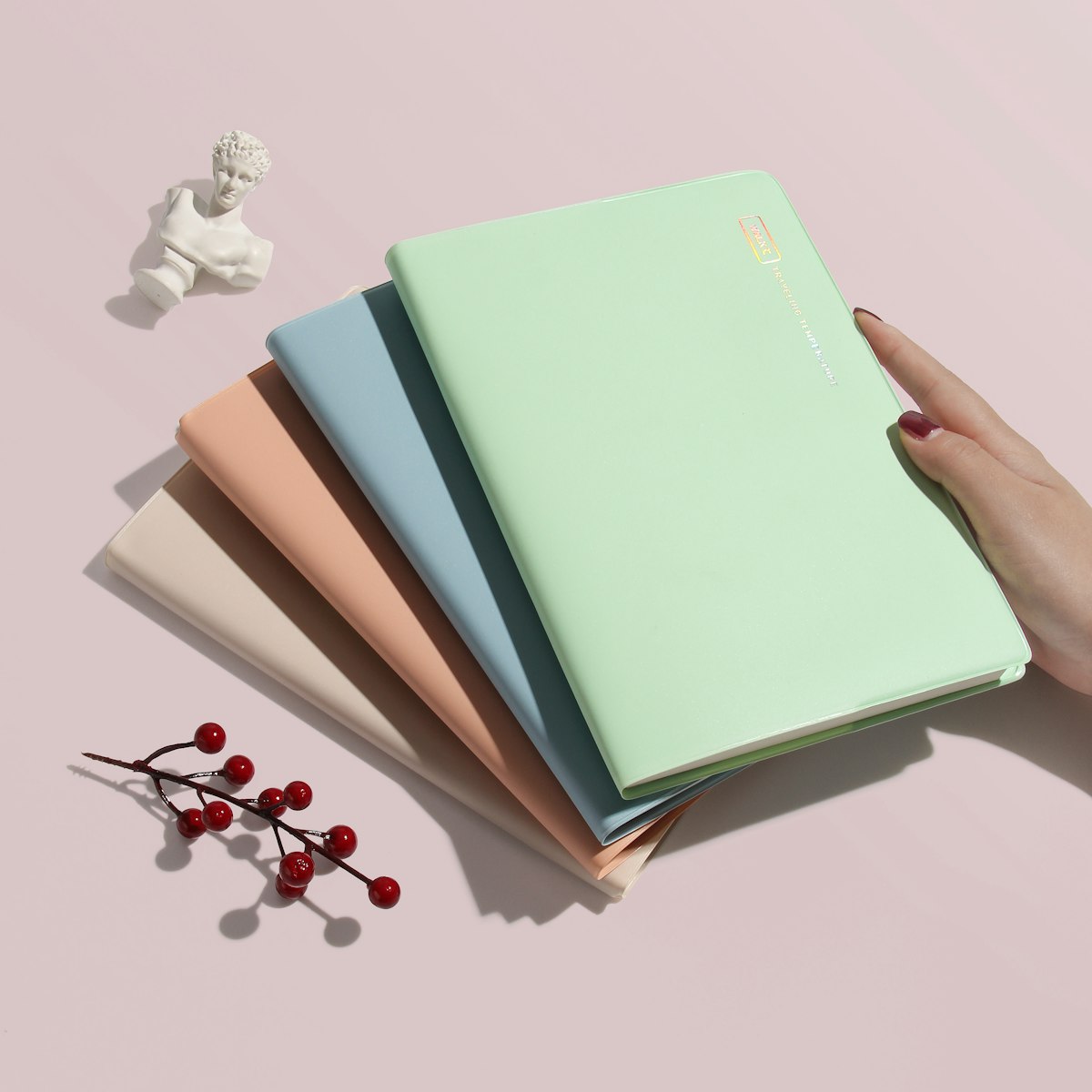 Sage green linen-covered A5 notebook held in hand